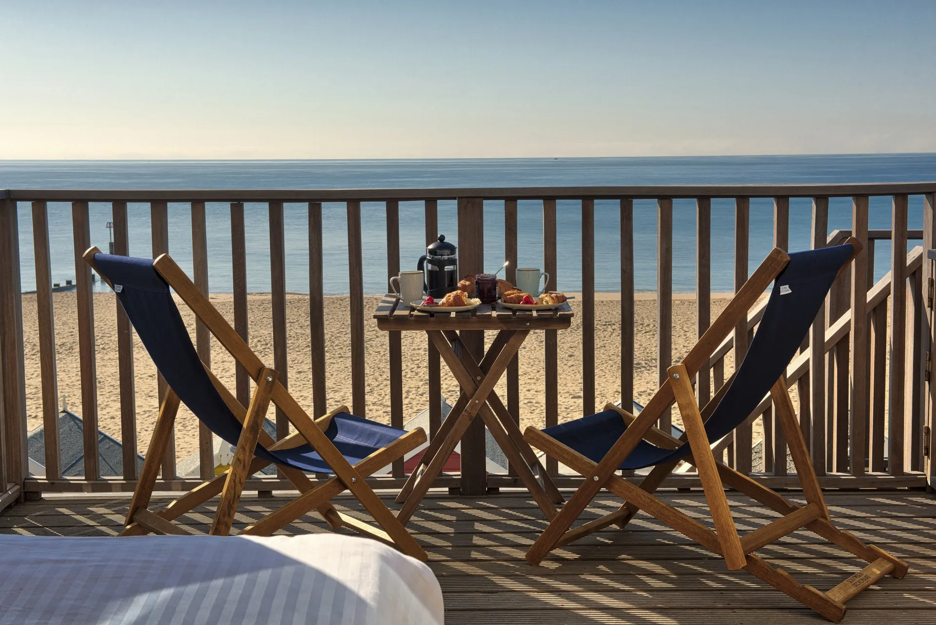 Deckchairs and table laid for breakfast on a lodge balcony