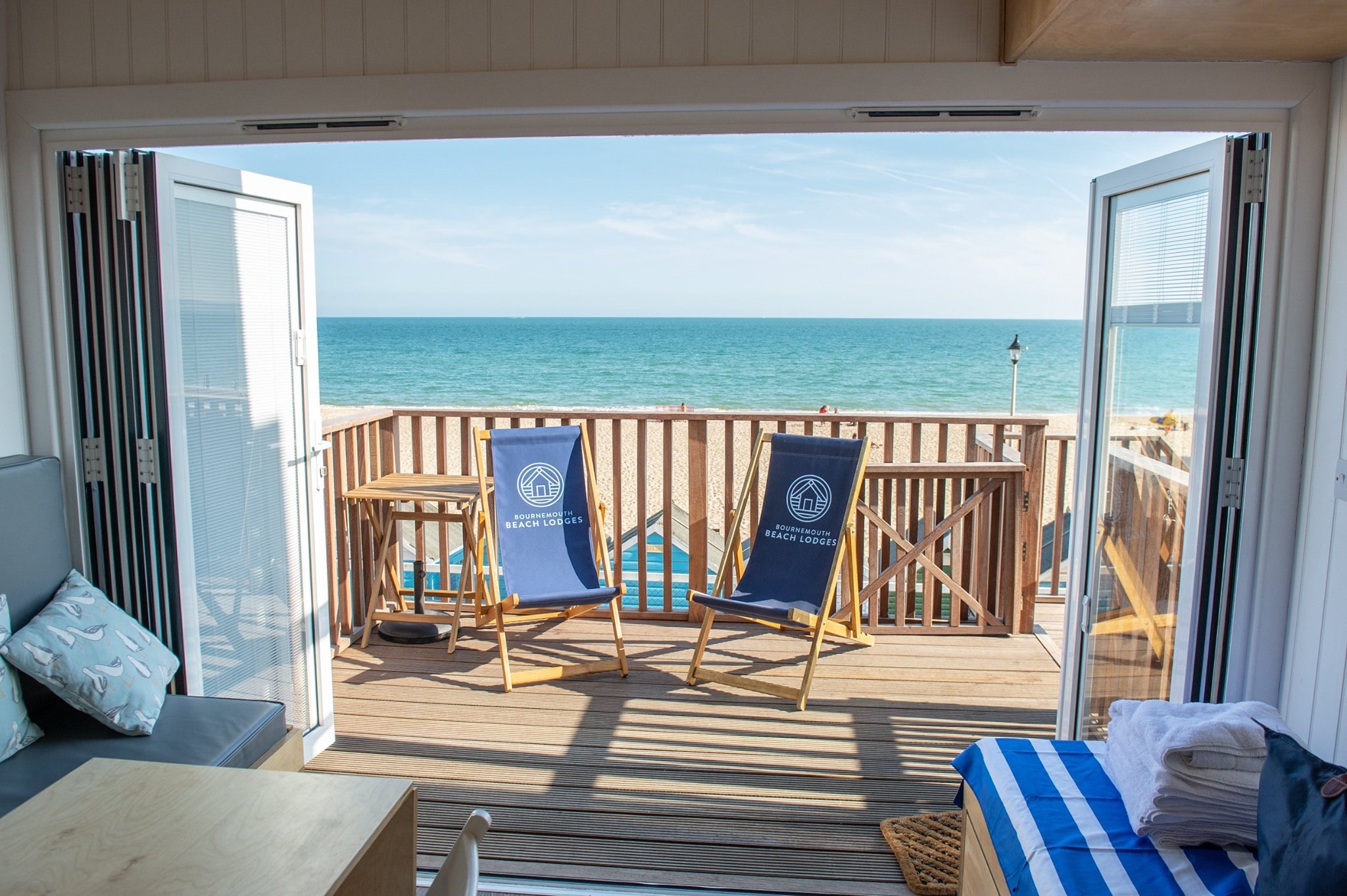 Summer view out of the Beach Lodges overlooking sea view terrace and sandy beach