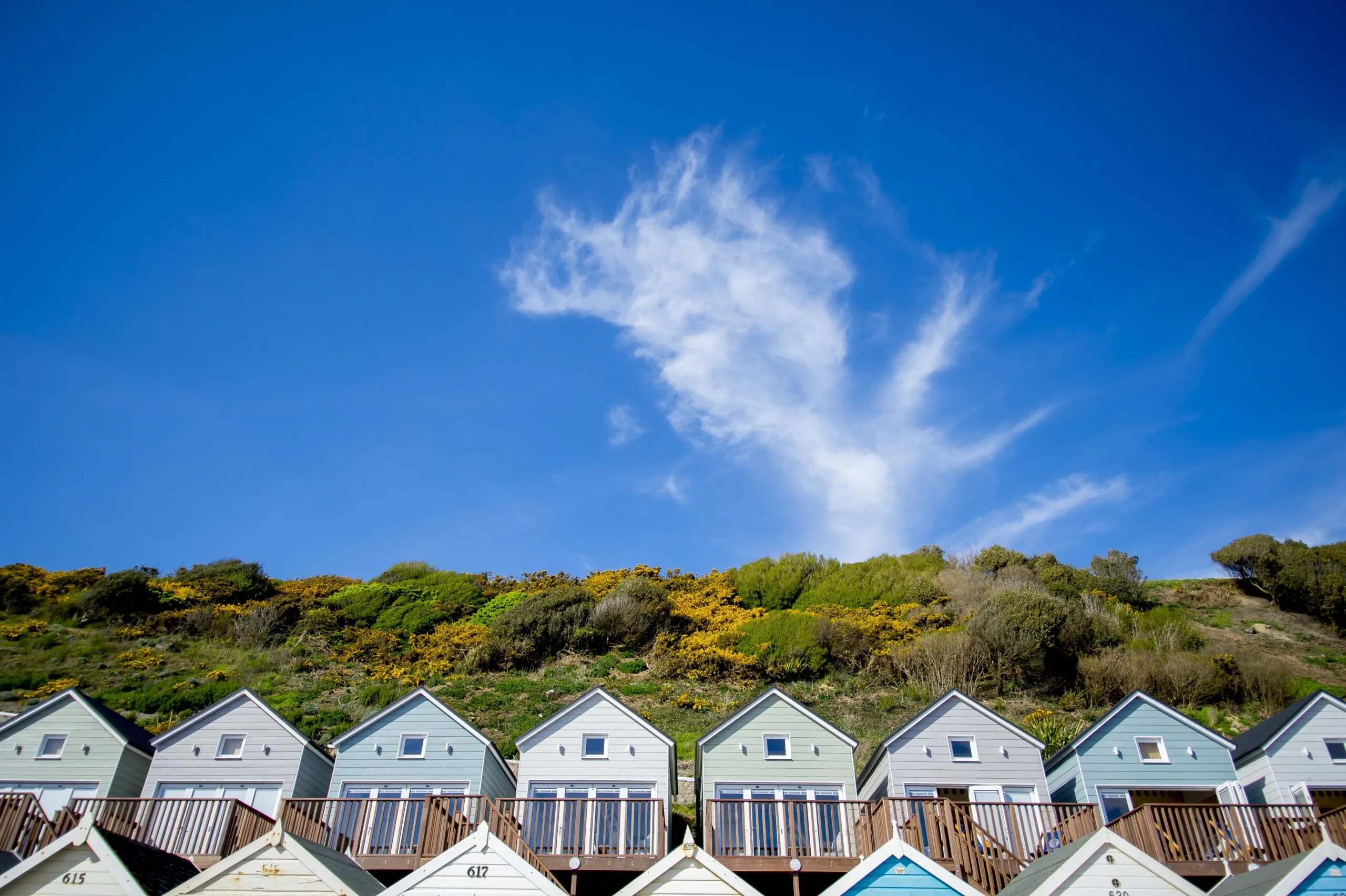 Row of Beach Lodges nestled in Cliff Top with clear blue sky
